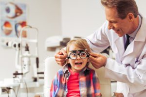 eye doctor putting lenses on child