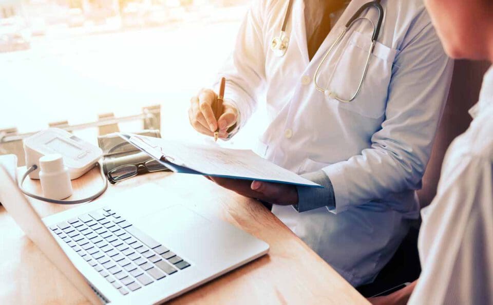 doctor talking to patient in front of laptop