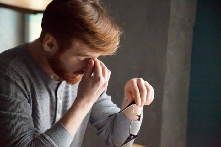 man with cataracts pinching nose