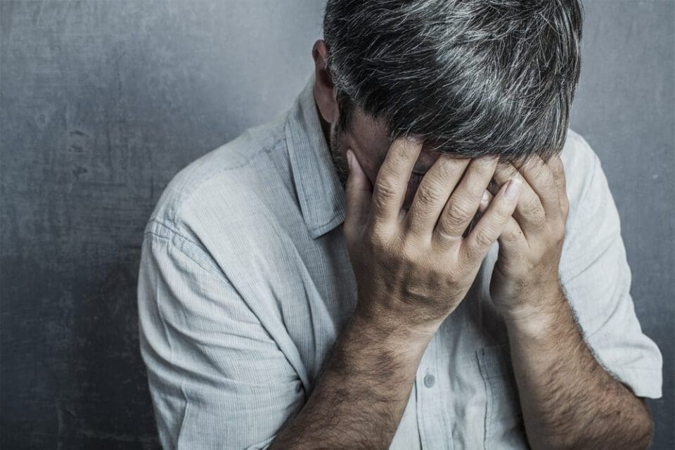 man covering eye in pain