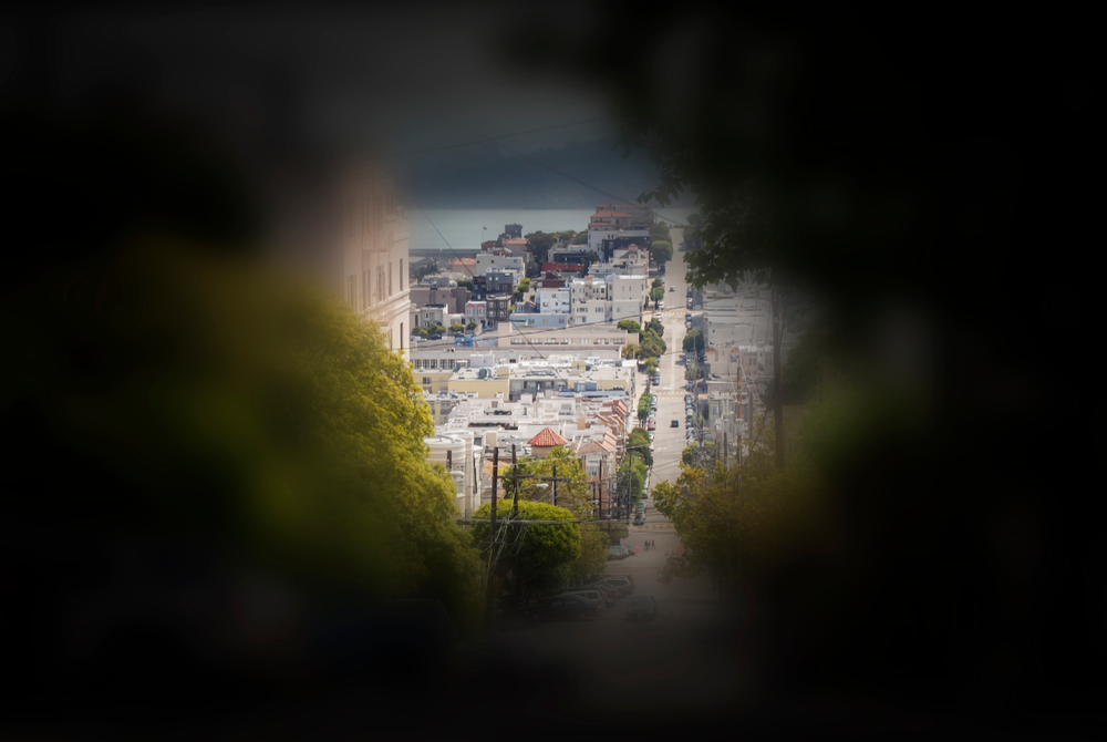 Seeing from the perspective of a patient with tunnel vision. The side vision is blurry while in the centre a clear view of a town with building can be seen.