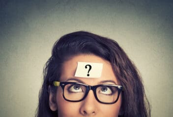 woman looking at questions mark post-it on forehead
