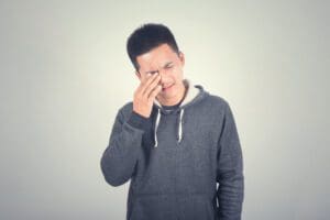 man rubbing eyes